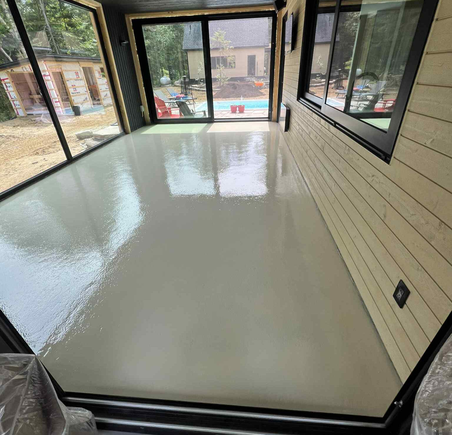 Plancher en époxy beige appliqué dans une pièce résidentielle, offrant une finition durable et facile d’entretien à Deux-Montagnes